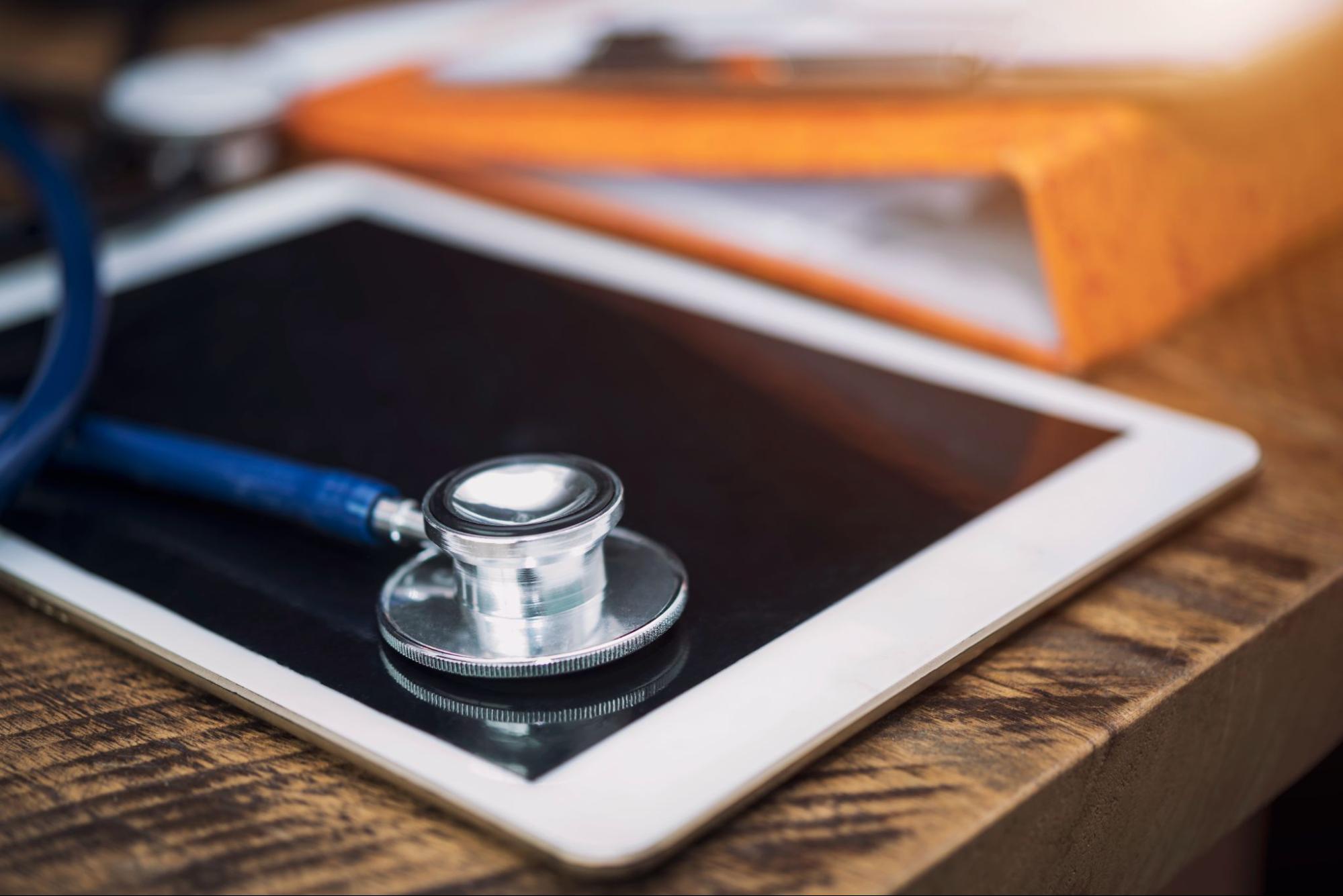 tablet and stethoscope on table