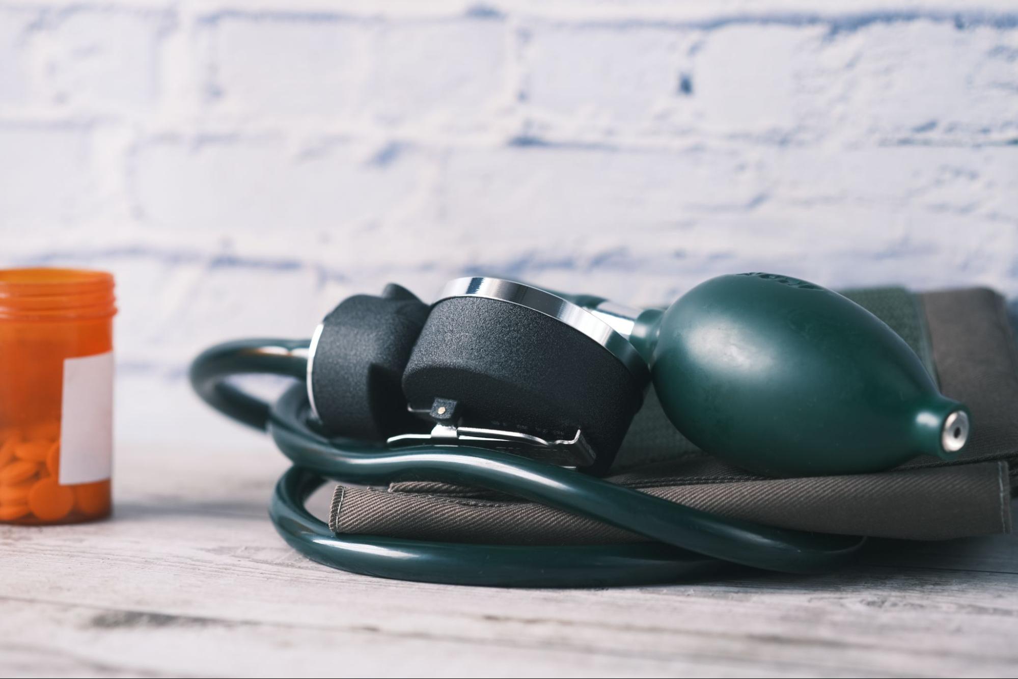 blood pressure monitor next to container of medication